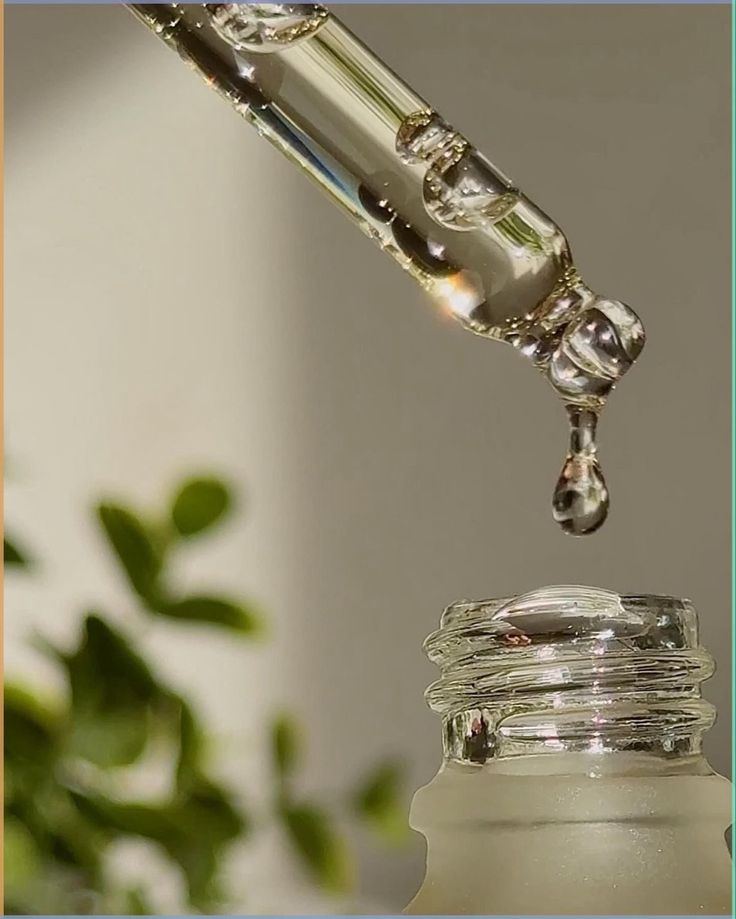 Pipeta gotejando soro transparente sobre frasco de vidro — textura leve de cosméticos veganos para skincare