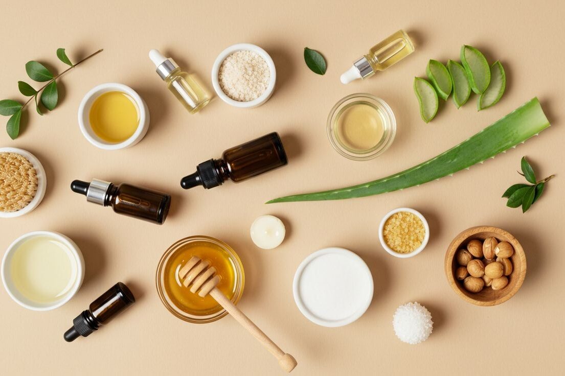 Flatlay com mel, aloe vera, óleos e cremes naturais — ingredientes essenciais de skincare vegano acessível